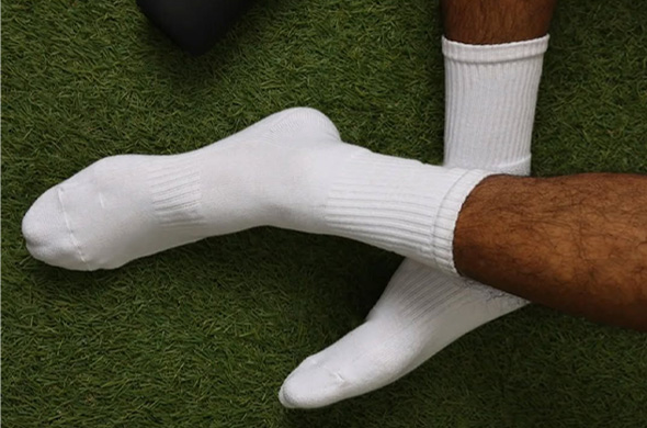 Durable white athletic crew socks shown on grass, perfect for outdoor sports