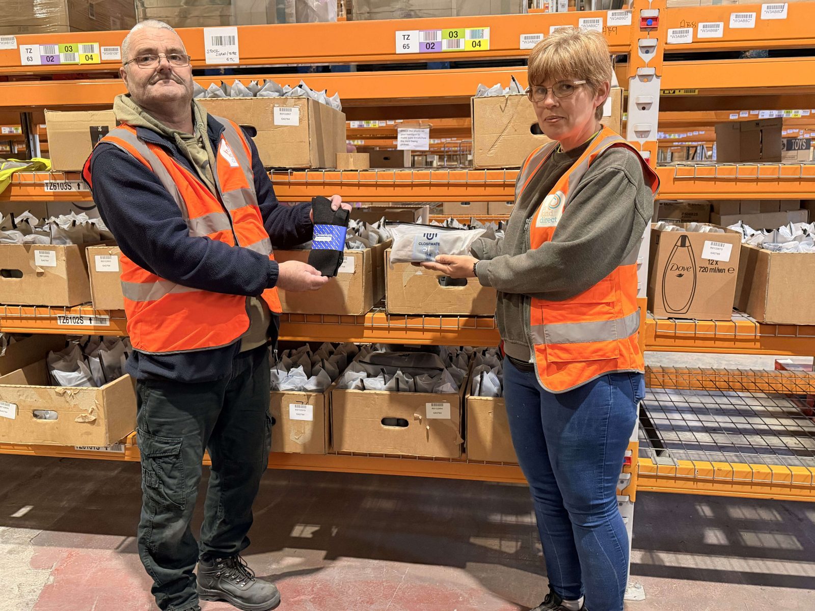 In Kind Direct warehouse staff holding CloseMate thermal socks and seamless bras being prepared for charity distribution.
